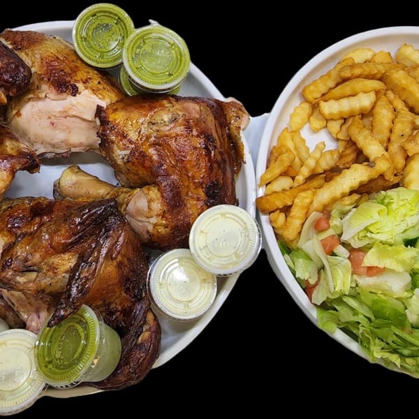 Pollo Xpress halal roasted chicken, fries, salad, black beans, and sauces on white plates.