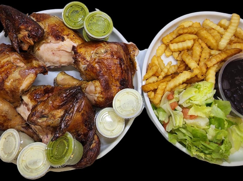 Pollo Xpress halal roasted chicken, fries, salad, black beans, and sauces on white plates.